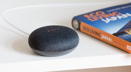 Google Home Assistant on a table with a book