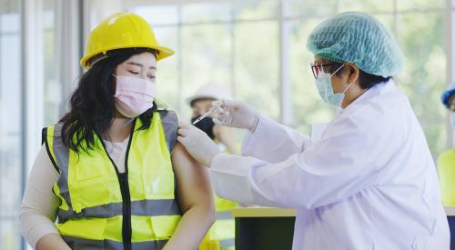 Woman construction worker getting vaccine shot