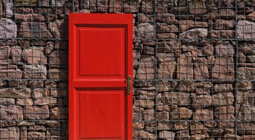 Red door in front of brick wall