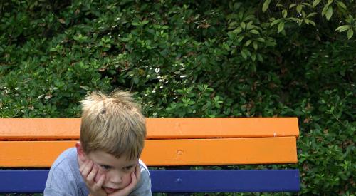 Boy on bench pouting