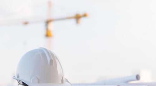 White hard hat and paper construction plans on job site
