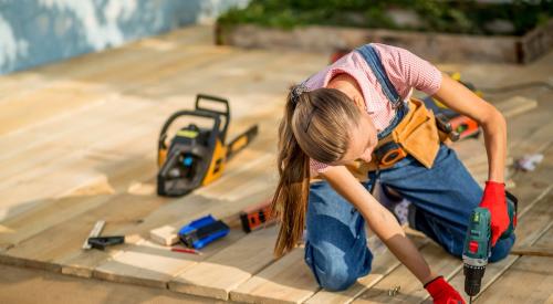 Women drilling nail into deck 