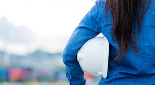 Woman holding white construction hard hat