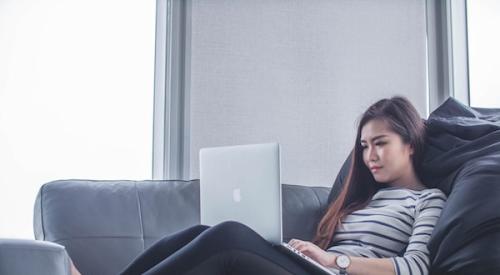 woman sitting on couch with laptop working from home