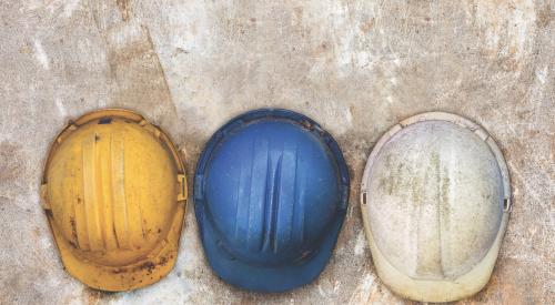 Yellow, blue, and white construction hard hats in a row